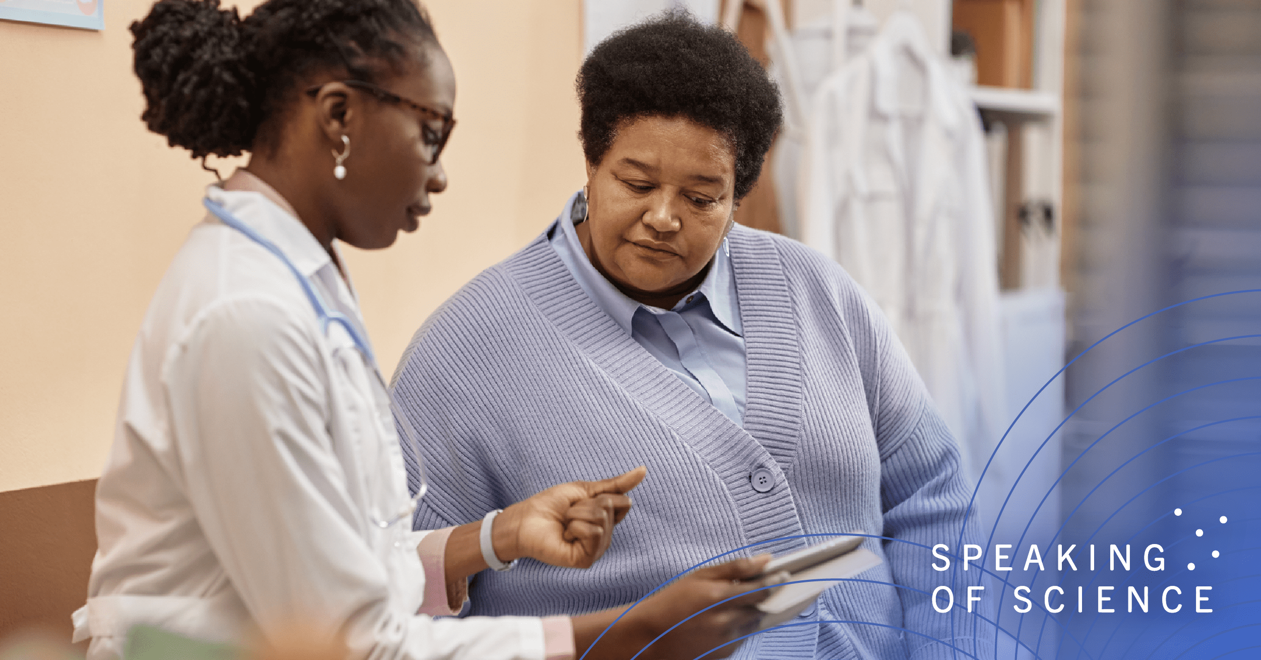 Physician in lab coat talking through written materials with patient